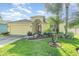 Lovely yellow home with a two-car garage, complemented by a vibrant lawn and lush tropical plants at 13194 Royal Pines Ave, Riverview, FL 33579