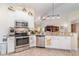 Bright kitchen features stainless steel appliances, granite countertops, and white cabinetry at 13194 Royal Pines Ave, Riverview, FL 33579