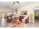 Inviting living room featuring comfortable leather sofas, a floral rug, and an open view into the kitchen at 13194 Royal Pines Ave, Riverview, FL 33579