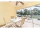 Enclosed patio with table, chairs, shell decor, and views of the fenced backyard at 13194 Royal Pines Ave, Riverview, FL 33579