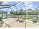 Enclosed patio featuring outdoor lounge chairs and a view of the green lawn at 13194 Royal Pines Ave, Riverview, FL 33579
