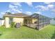 View of the screened patio with brick flooring, patio furniture, and green lawn at 13194 Royal Pines Ave, Riverview, FL 33579