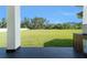 The backyard view from the covered patio showcases a sprawling green lawn at 14080 Sydney Rd, Dover, FL 33527