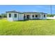 Expansive backyard featuring a covered patio, outdoor kitchen, and lush green lawn at 14080 Sydney Rd, Dover, FL 33527
