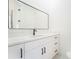 This bathroom has a modern vanity with white cabinets, drawers, a black faucet, and a large mirror at 14080 Sydney Rd, Dover, FL 33527