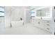 Elegant bathroom featuring a soaking tub, marble-look tile, and modern fixtures at 14080 Sydney Rd, Dover, FL 33527