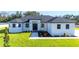 An attractive single-story home features a white exterior, dark roof, manicured lawn, and a welcoming entry at 14080 Sydney Rd, Dover, FL 33527