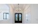Bright foyer featuring a decorative chandelier, and a stunning glass-paneled front door at 14080 Sydney Rd, Dover, FL 33527