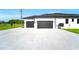 Spacious driveway leading to a two-car garage with black garage doors at 14080 Sydney Rd, Dover, FL 33527