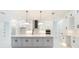 Modern kitchen features white cabinetry, gray island, stainless steel appliances, and stylish pendant lighting at 14080 Sydney Rd, Dover, FL 33527