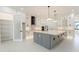 Well-appointed kitchen features gray island, quartz countertops, white cabinets, and stainless steel appliances at 14080 Sydney Rd, Dover, FL 33527