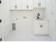 This laundry room is brightly lit and features modern cabinetry, a black faucet, and a sink at 14080 Sydney Rd, Dover, FL 33527