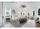Luxurious main bedroom boasts many windows, a decorative ceiling fan, and modern furniture at 14080 Sydney Rd, Dover, FL 33527