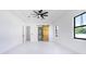 Bright main bedroom features a tray ceiling with a ceiling fan and an en suite bathroom with barn door at 14080 Sydney Rd, Dover, FL 33527