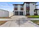 Spacious two-car garage and extra-long driveway of modern white home with gray accents and manicured lawn at 1500 49Th N St, St Petersburg, FL 33710