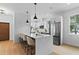 Modern white kitchen with stainless steel appliances, pendant lighting and a large island with bar seating at 1500 49Th N St, St Petersburg, FL 33710