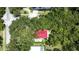 Aerial view of a red roofed home surrounded by mature trees and a pool at 16006 Armistead Ln, Odessa, FL 33556