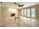 Bright living room featuring a fireplace, ceiling fan, and sliding doors leading to a lush yard at 16006 Armistead Ln, Odessa, FL 33556