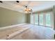 Spacious room with a ceiling fan and large sliding doors, ready for renovation at 16006 Armistead Ln, Odessa, FL 33556