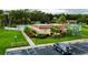 View of community pool, clubhouse, parking and lawns with mature palms at 1701 Pinehurst Rd # 33E, Dunedin, FL 34698