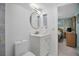 Modern bathroom featuring a stylish round mirror, gold faucet, white cabinets, with view to bedroom at 1701 Pinehurst Rd # 33E, Dunedin, FL 34698