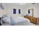 Comfortable bedroom featuring a striped bedspread, wood dresser, and natural light from a window at 1701 Pinehurst Rd # 33E, Dunedin, FL 34698