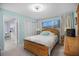 Comfortable bedroom with a wood bed frame, light blue walls and natural light from the window view at 1701 Pinehurst Rd # 33E, Dunedin, FL 34698