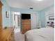 Comfortable bedroom with a wood bed frame, light blue walls with connecting access to a bathroom and closet at 1701 Pinehurst Rd # 33E, Dunedin, FL 34698