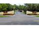 The entrance to Pinehurst Village with lush landscaping, signage, and a view of the community at 1701 Pinehurst Rd # 33E, Dunedin, FL 34698