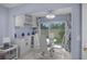 The dining area features a modern light fixture, glass table, white chairs, and a built-in wine rack and cabinets at 1701 Pinehurst Rd # 33E, Dunedin, FL 34698