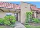 Charming front entrance with a red tile roof and a welcoming, well-maintained landscaped garden at 1701 Pinehurst Rd # 33E, Dunedin, FL 34698