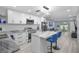 Modern kitchen with white cabinets, stainless steel appliances, marble countertop island and stylish blue bar stools at 1701 Pinehurst Rd # 33E, Dunedin, FL 34698
