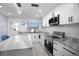 A modern kitchen featuring stainless steel appliances, white cabinetry, and sleek countertops, all bathed in natural light at 1701 Pinehurst Rd # 33E, Dunedin, FL 34698