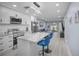 Modern kitchen with white cabinets, stainless steel appliances, marble countertop island and stylish blue bar stools at 1701 Pinehurst Rd # 33E, Dunedin, FL 34698