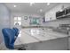 Close-up of modern kitchen island with marble countertop and stylish blue barstools at 1701 Pinehurst Rd # 33E, Dunedin, FL 34698