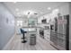 Stylish kitchen with marble countertops, white cabinets, modern appliances and bar seating at 1701 Pinehurst Rd # 33E, Dunedin, FL 34698