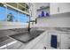 Bright kitchen featuring a stainless sink, black faucet and sleek countertop with decoratively placed blue vases on the shelf at 1701 Pinehurst Rd # 33E, Dunedin, FL 34698