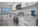 Modern kitchen with stainless steel appliances, white cabinets with black hardware, and stylish countertop on gray floors at 1701 Pinehurst Rd # 33E, Dunedin, FL 34698