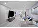 Open-concept living room featuring a large TV, modern fireplace, and views into the kitchen at 1701 Pinehurst Rd # 33E, Dunedin, FL 34698