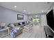 Spacious living room with gray sectional couch, white floors, and bright natural light at 1701 Pinehurst Rd # 33E, Dunedin, FL 34698