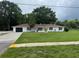 Charming single-story home with a well-manicured lawn and a large driveway at 17048 State Road 54, Lutz, FL 33558