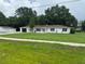 Attractive single-story home featuring a spacious lawn and a detached garage at 17048 State Road 54, Lutz, FL 33558