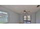 Bedroom with a ceiling fan, sliding glass doors to the outside, and a window letting in natural light at 1717 Atrium Dr, Sun City Center, FL 33573