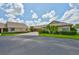 Exterior view of a home featuring well-maintained landscaping, plants, and a driveway at 1717 Atrium Dr, Sun City Center, FL 33573
