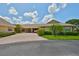 Exterior view of home with yellow facade, well-maintained landscaping, driveway, and covered carport at 1717 Atrium Dr, Sun City Center, FL 33573