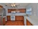 Kitchen showcasing wood cabinetry and stainless steel appliances at 1717 Atrium Dr, Sun City Center, FL 33573