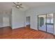 Bright living room with hardwood floors, a ceiling fan, and a sliding glass door to the patio at 1717 Atrium Dr, Sun City Center, FL 33573