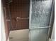 This bathroom features a shower with brown tiling and a safety bar for ease of access at 1813 Laurel Oak Dr, Valrico, FL 33596