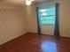 Bedroom featuring wood floors, wallpaper, a ceiling fan, and a window for natural light at 1813 Laurel Oak Dr, Valrico, FL 33596