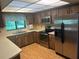 This kitchen includes stainless steel appliances and light countertops with dark cabinetry at 1813 Laurel Oak Dr, Valrico, FL 33596